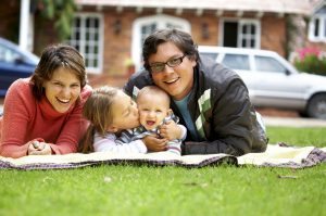 happy family smiling in a portrait of a mum and dad with their two kids